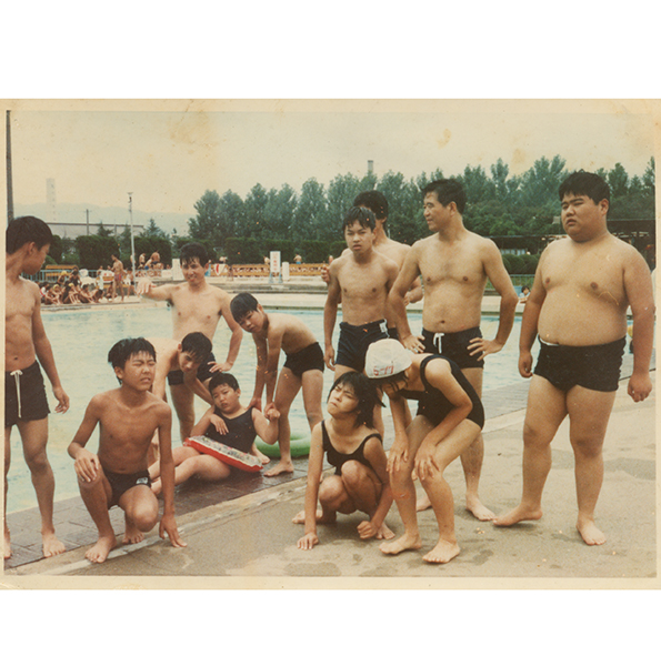 父は中学の先生で、生徒の後ろで小さく写真に。
